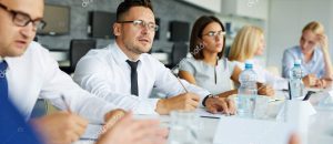 Group of People Sitting At a Table After Receiving Employee Benefits in Loveland, Fort Collins, Greeley, Windsor, and Longmont