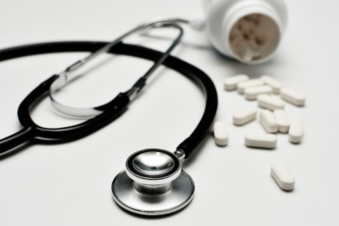 Stethoscope with Pills Out of Bill Bottle on Table for Medicare Insurance in Fort Collins, Greeley, Longmont, Loveland, and Windsor