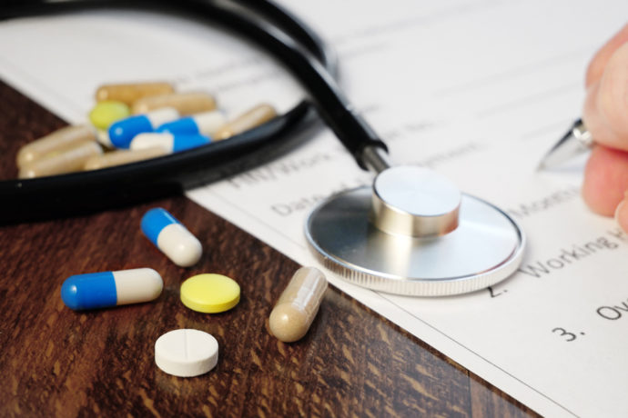 Medical Insurance with a stethoscope and and pills on a table in Longmont, CO